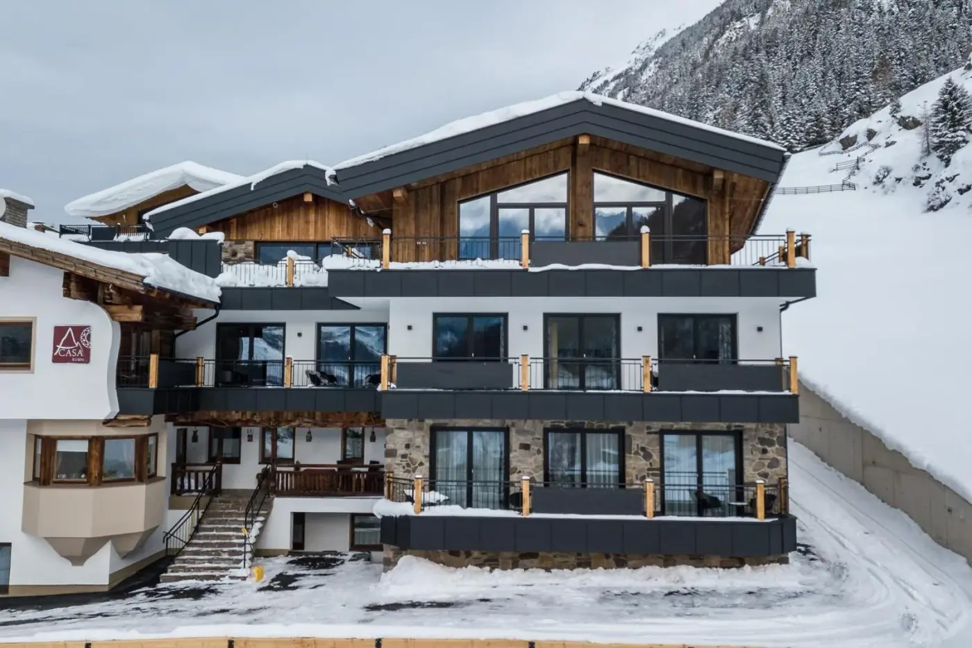 Alpine chalet resort exterior with dark balconies surrounded by snow at A CASA Rubin Chalet in Sölden, Austria.