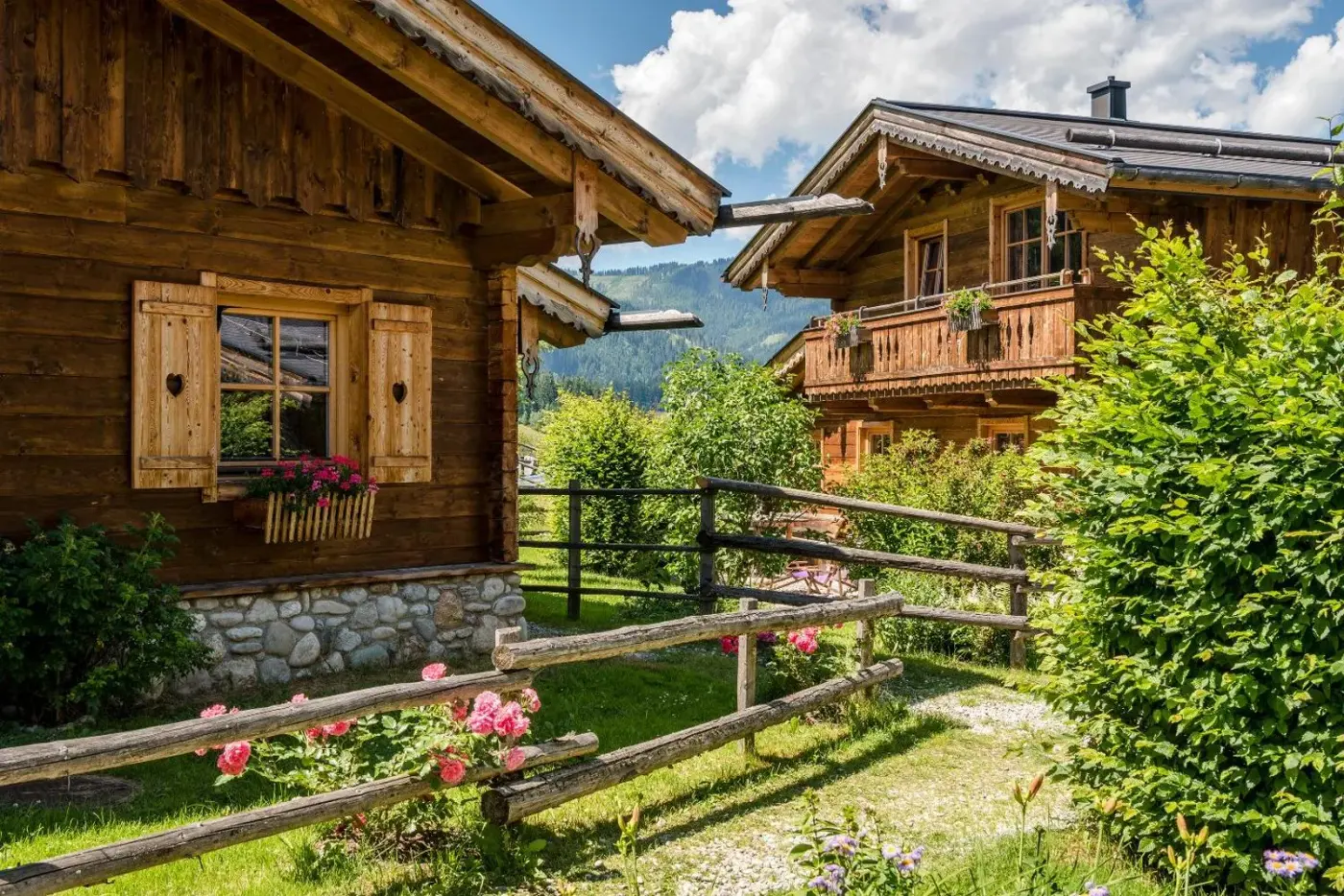 Timber chalet exteriors with balconies and garden planting at almlust in Flachau, Austria.