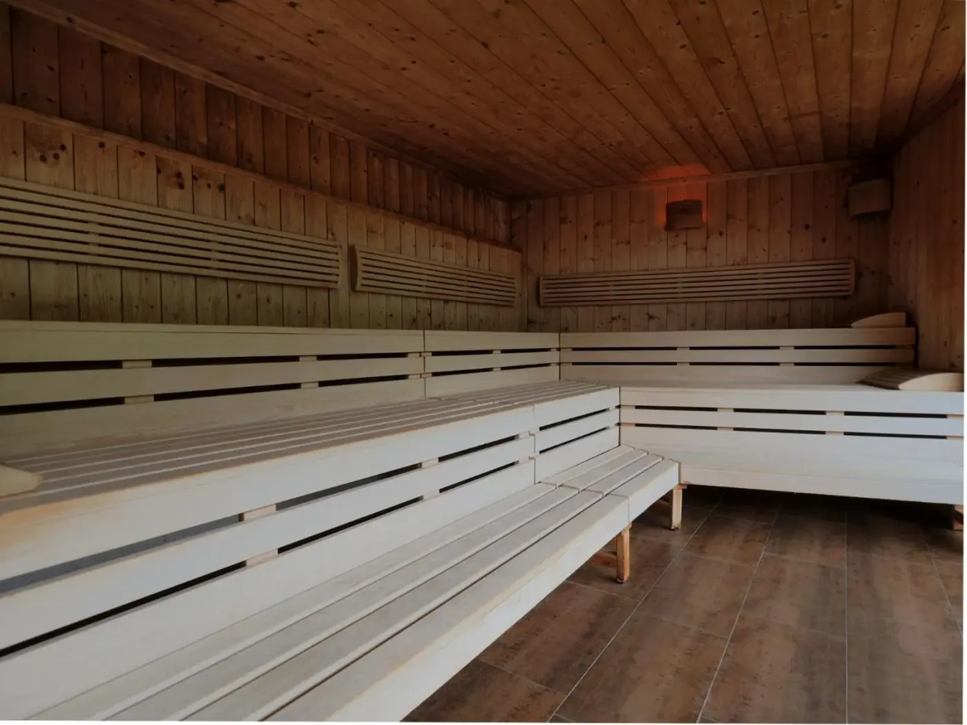 Wooden sauna with long tiered benches at Aparthotel Alpinresort Damüls in Damüls, Austria.