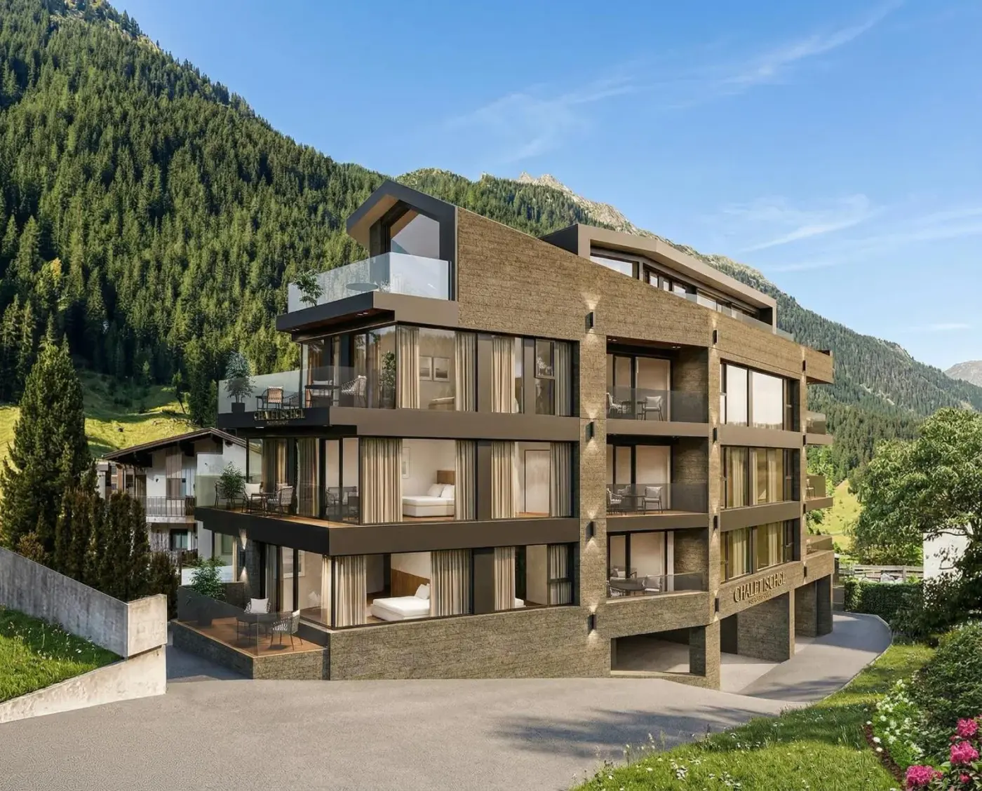 Modern apartment building with broad balconies beneath forested mountains at Chalet Ischgl in Ischgl, Austria.