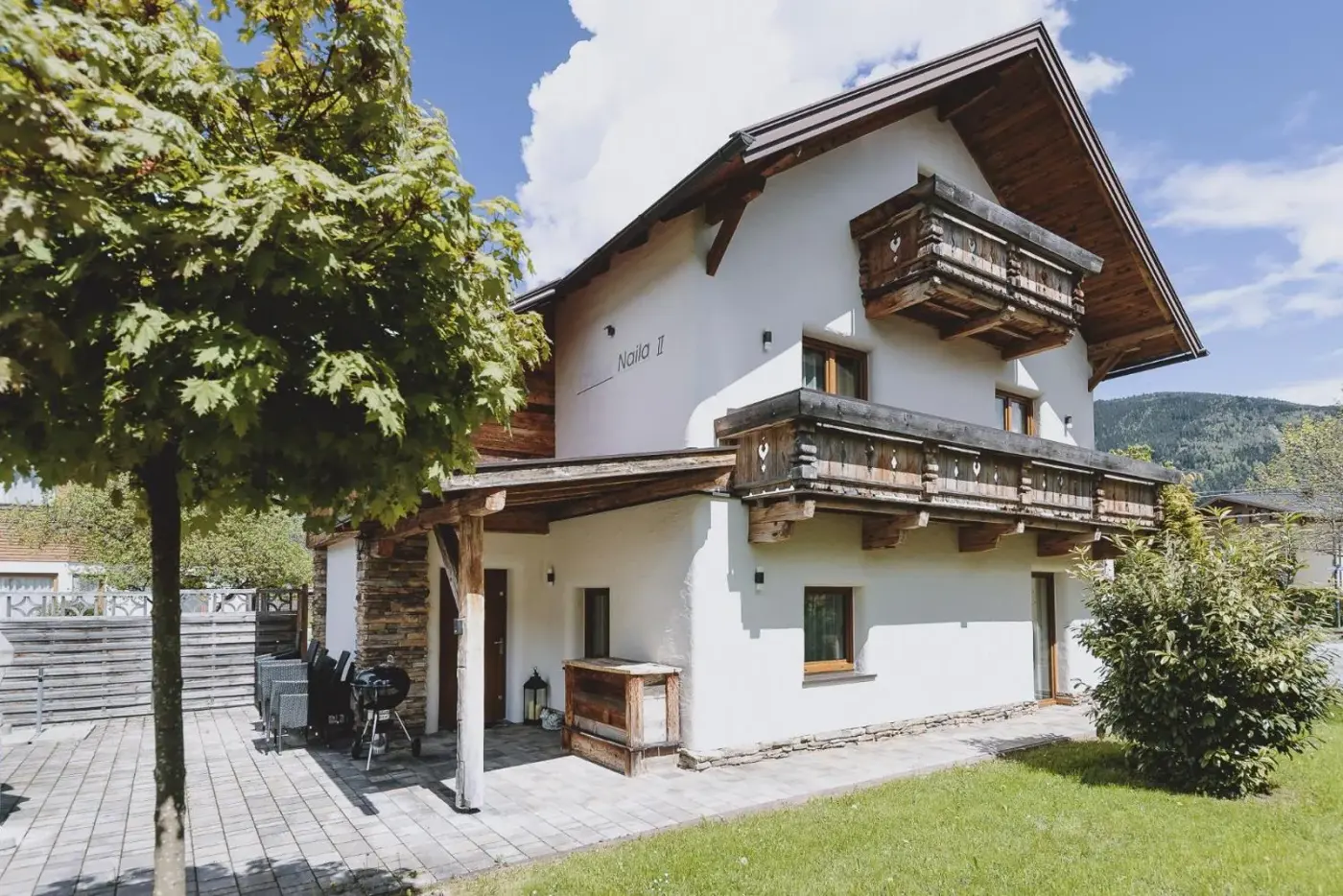 Alpine chalet with timber balconies beside a green garden at Chalet Molly by we rent in Zell am See, Austria.