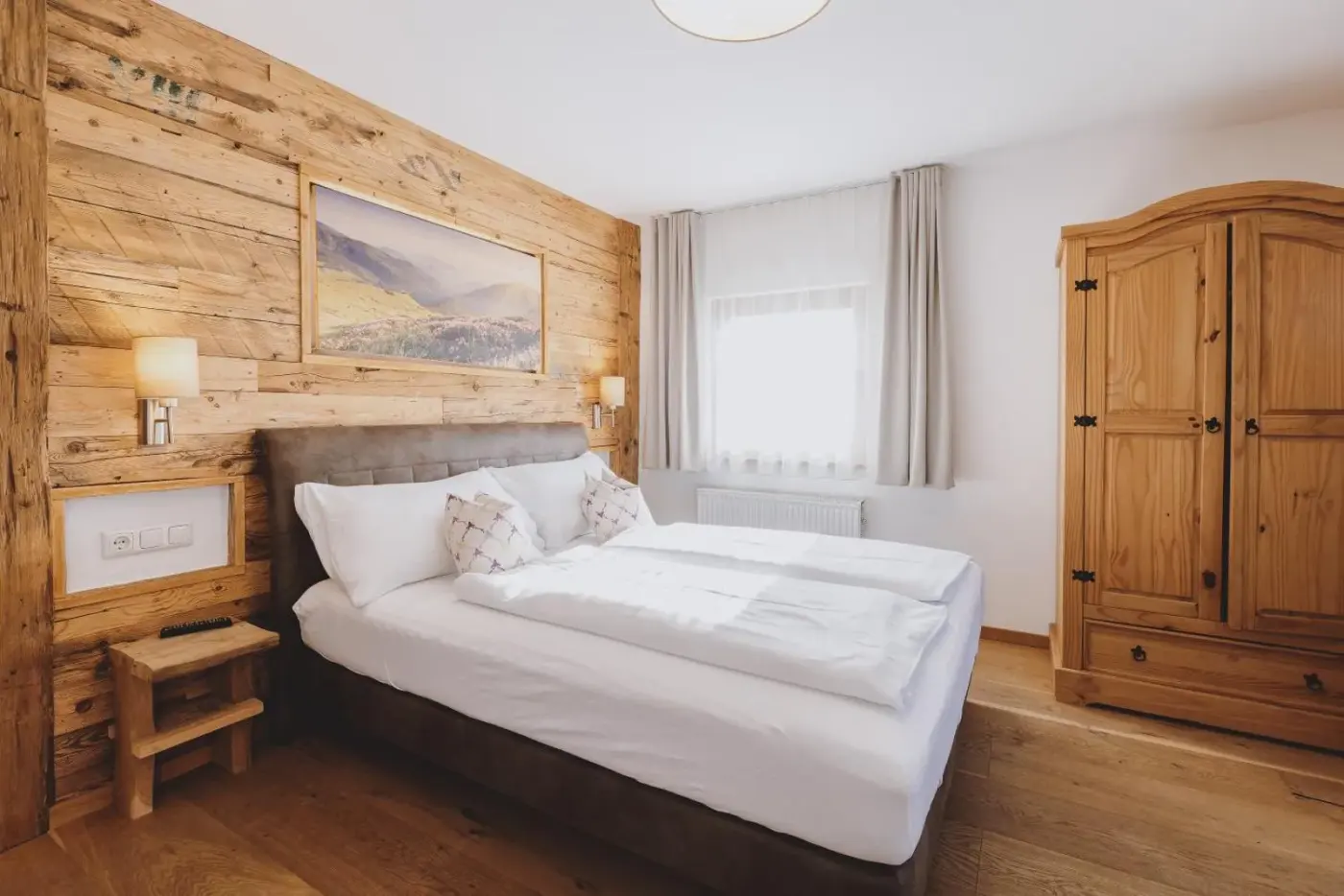 Double bedroom with a timber headboard and wardrobe at Chalet Molly by we rent in Zell am See, Austria.