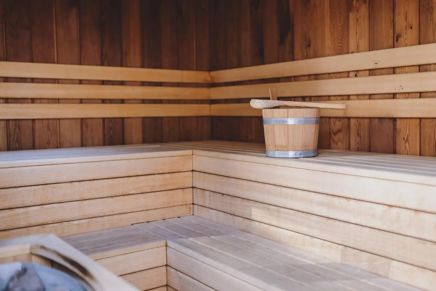 Timber sauna with tiered benches and a wooden bucket at Chalet Molly by we rent in Zell am See, Austria.