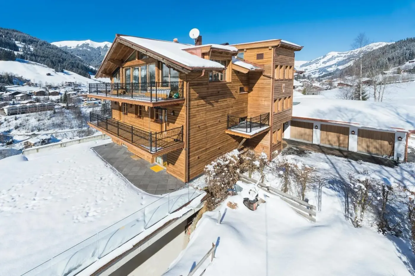 Timber chalet apartment building surrounded by snow at Das Kitz ChaletApartments in Jochberg, Austria.
