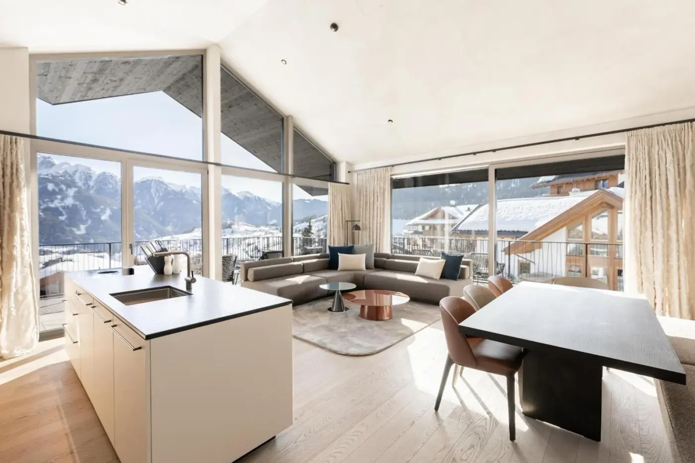 Open-plan kitchen and living room with wide mountain-facing windows at Domenigs Luxury Apartments in Fiss, Austria.