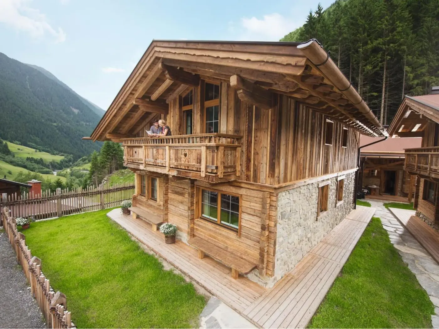Timber chalet with balconies in a forested mountain valley at Gletscher Chalet in Neustift im Stubaital, Austria.