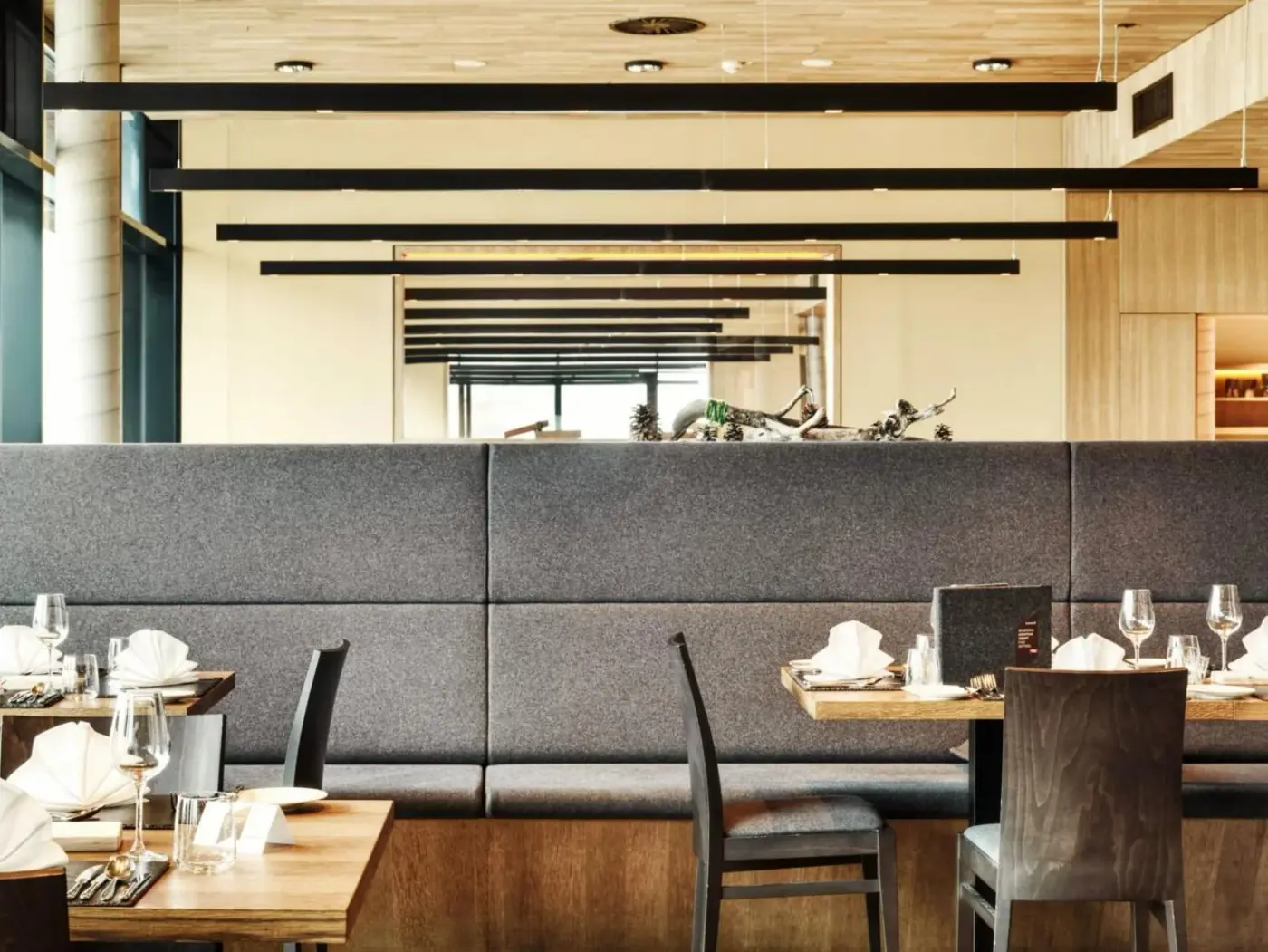 Restaurant with booth seating and neatly set tables at Gradonna Mountain Resort Chalets and Hotel in Kals am Großglockner, Austria.